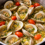 Fresh little neck clams simmering in beer and garlic butter broth in a large pot