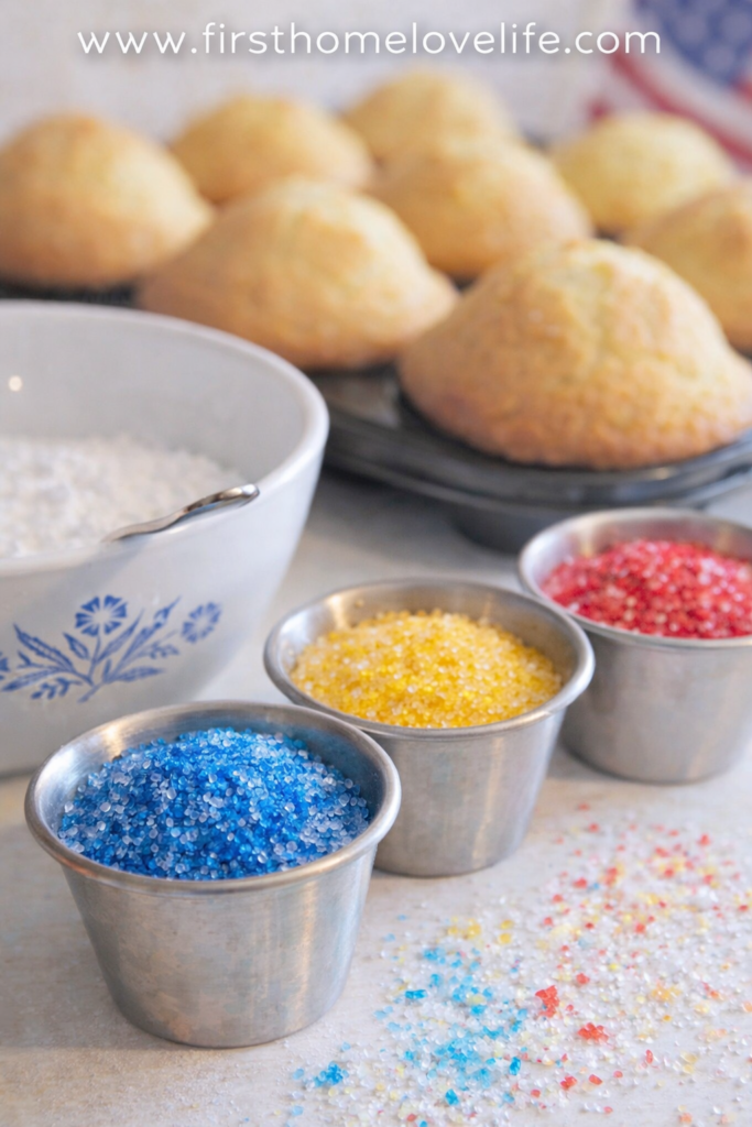 Colored sugar for snow cone cupcakes with baked cupcakes cooling in the background