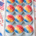 Bird’s-eye view of snow cone cupcakes lined up on a white serving tray