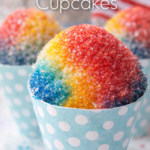 Snow cone cupcakes with red, yellow, and blue sugar topping in pastel paper cones
