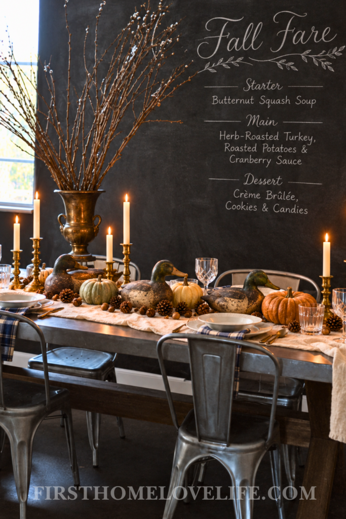 Wide English hunter fall tablescape with duck decoys, muted pumpkins, brass candles, tartan napkins, and a chalkboard fall menu.