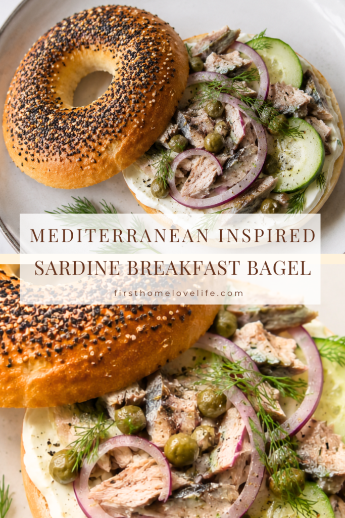 Mediterranean-inspired sardine breakfast bagel topped with cream cheese, cucumber, red onion, capers, and fresh dill on a white plate.