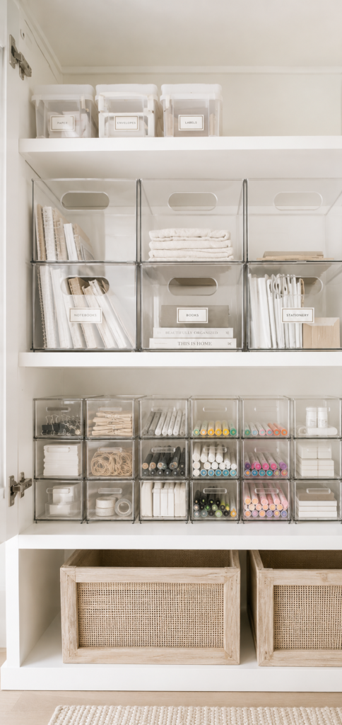 Organized school supply cabinet with clear storage bins, labeled containers, and neutral baskets for easy back-to-school organization.
