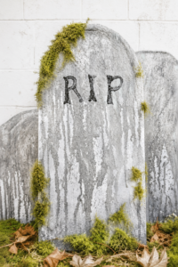 Weathered DIY Halloween tombstones with faux moss accents, aged stone texture, and spooky graveyard styling for outdoor Halloween yard decorations.