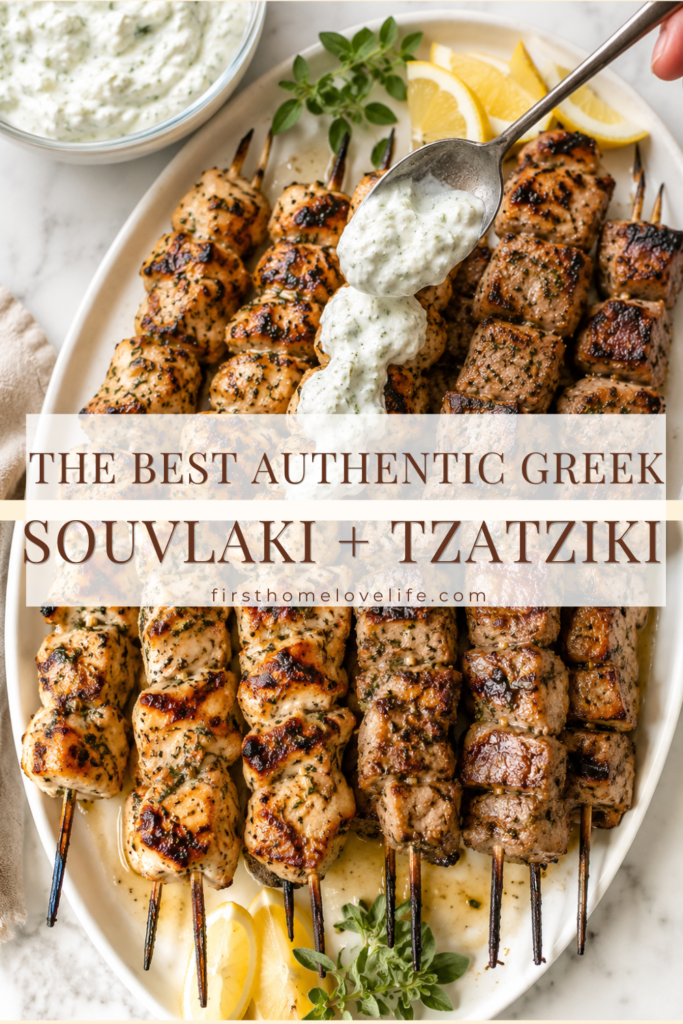 Vertical Pinterest image of grilled Greek chicken and pork souvlaki on a white platter with homemade tzatziki being spooned over the chicken skewers, garnished with lemon wedges and fresh oregano on a marble countertop.