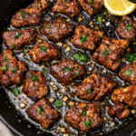 Garlic miso butter steak bites seared in a cast iron skillet with fresh parsley and lemon.