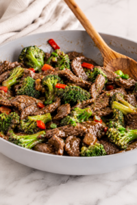 Chinese beef and broccoli stir fry in a skillet with tender sliced beef, fresh broccoli, and savory garlic ginger sauce.