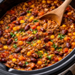 Crockpot taco chili cooking in a slow cooker with ground beef, beans, corn, and tomatoes