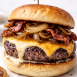 Irish pub burger with melted cheddar cheese, crispy bacon, and caramelized onions on a toasted brioche bun