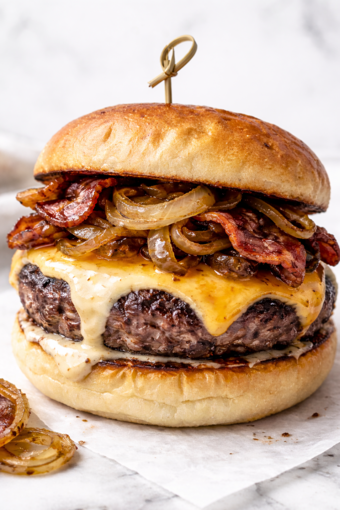 Irish pub burger with melted cheddar cheese, crispy bacon, and caramelized onions on a toasted brioche bun