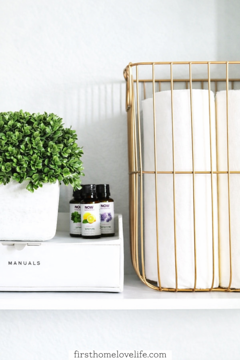laundry room shelf organization with gold wire basket toilet paper and plant decor