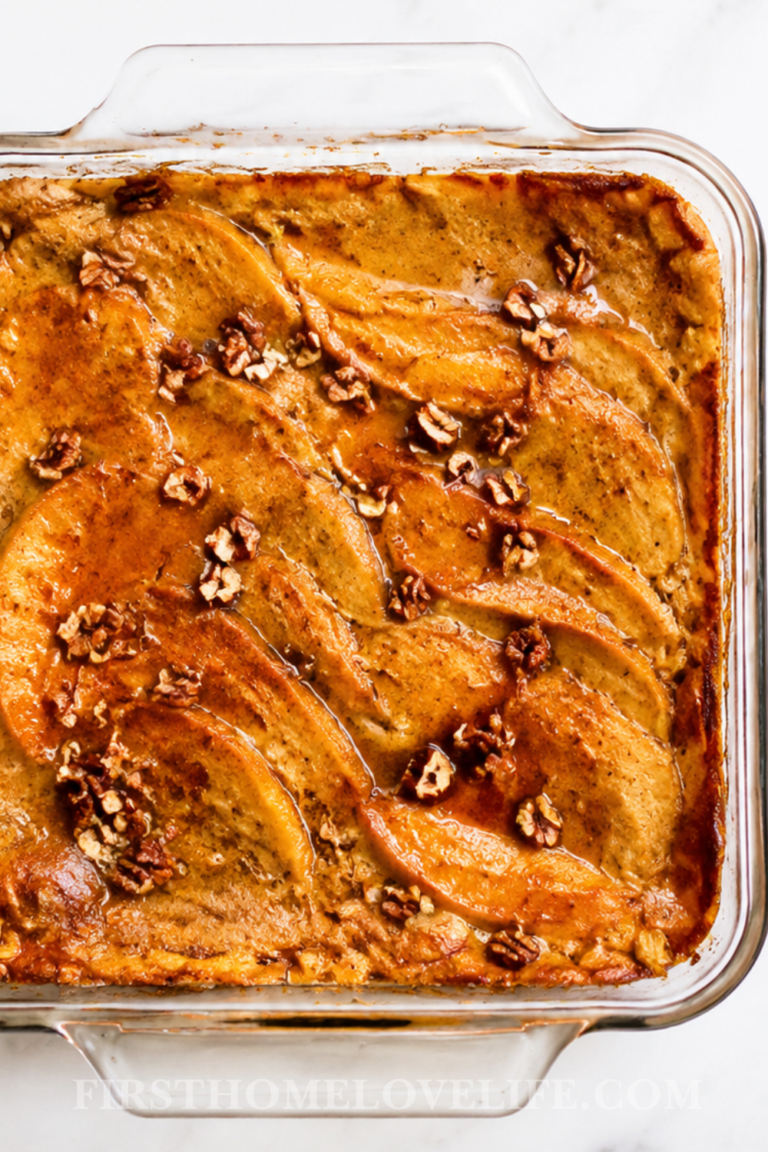 Overhead view of cinnamon pumpkin pancake cake baked in a clear glass dish with maple syrup and chopped pecans