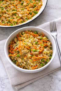 Easy 15 minute pork fried rice served in a white bowl on a neutral linen towel over a marble countertop.