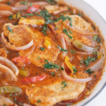 Close up of one pot pork chops and peppers in tomato sauce with onions and parsley