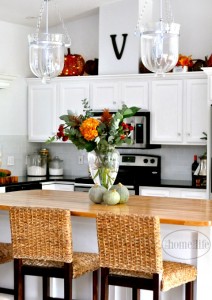 White kitchen cabinets with butcher block island. Beautiful white kitchen with subway tiles decorated for fall. Via First Home Love Life www.firsthomelovelife.com