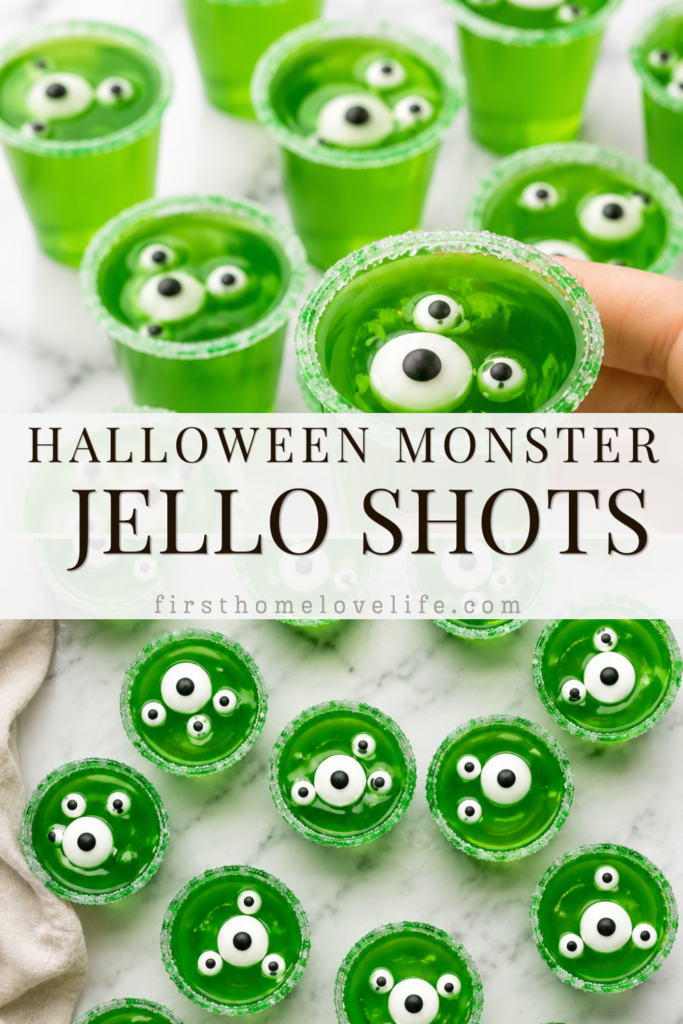 Hand picking up a bright green Monster Jello Shot with candy eyeballs from a marble countertop surrounded by spooky Halloween jello shots.