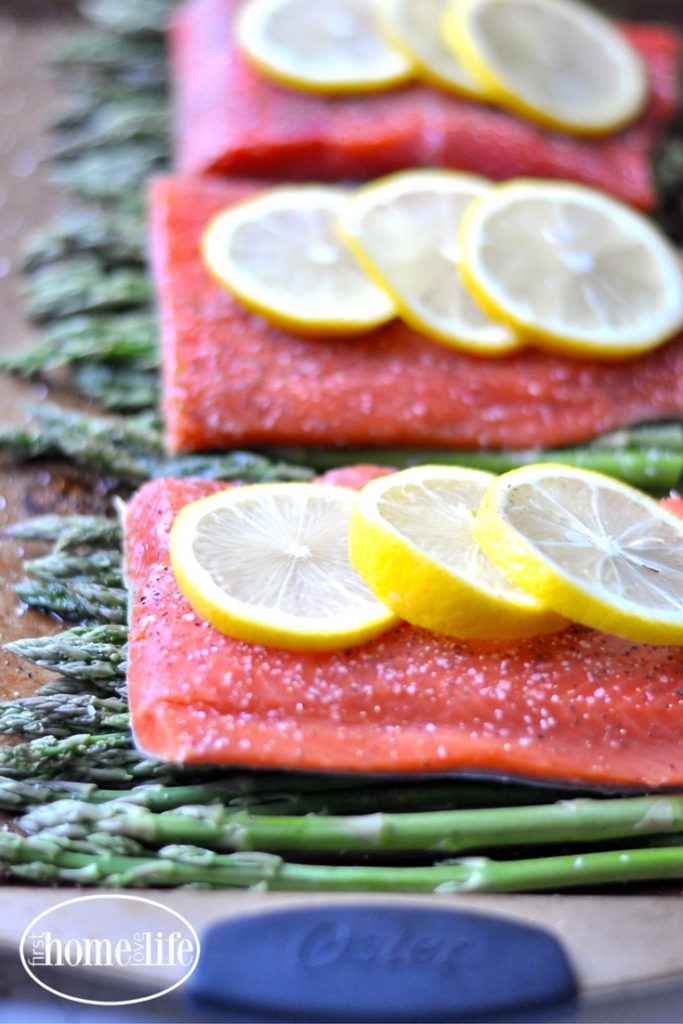Healthy sheet pan dinner idea | Salmon with lemon and asparagus with a garlic yogurt sauce via firsthomelovelife.com