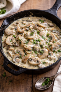 Creamy mushrooms in sour cream sauce served in a cast iron skillet, easy 20-minute mushroom side dish