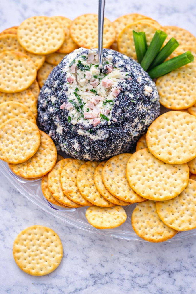 smokey ham crack dip cheese ball coated in poppy seeds and served with round crackers