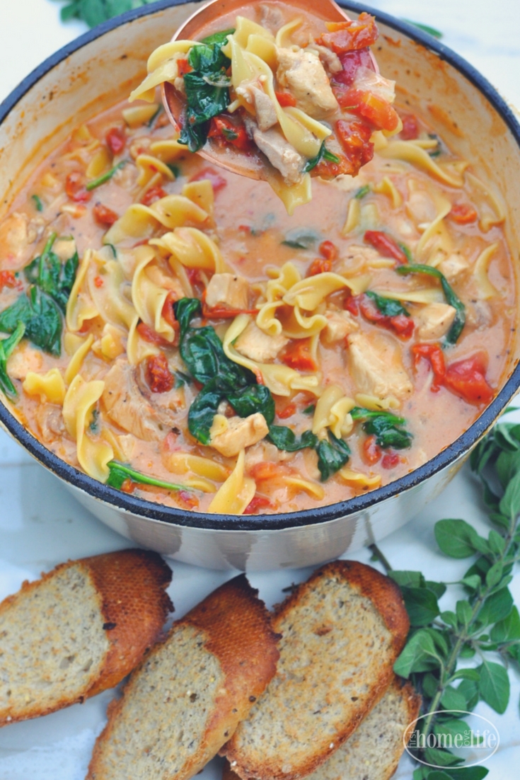 Creamy Tuscan chicken noodle soup is the perfect cold weather meal! Loaded with chicken, noodles, sun dried tomatoes and spinach in a creamy garlic tomato broth! via firsthomelovelife.com