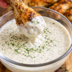 grilled chicken wing dipped into creamy alabama white bbq sauce