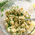 Fresh herb compound butter for poultry made with rosemary, parsley, garlic, and lemon in a glass bowl, ready to spread on chicken or turkey.