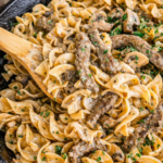 Creamy blue cheese beef stroganoff with mushrooms and egg noodles in a cast iron skillet