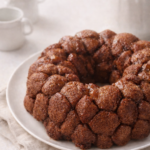 Soft banana monkey bread baked in a bundt pan with cinnamon sugar pull-apart pieces on a neutral linen background