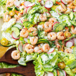 Creamy dill shrimp salad with avocado, cucumber, radishes, and tomatoes served on butter lettuce with a rich mayo sour cream dressing.