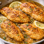 Garlic butter Creole chicken searing in a one pan skillet with herbs and lemon slices