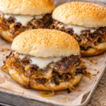 Depression Era onion smash cheeseburgers with caramelized onions and melted American cheese on a parchment-lined tray