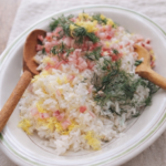 Easy herb rice salad with red onion, lemon zest, and fresh dill served in a white bowl on neutral linen
