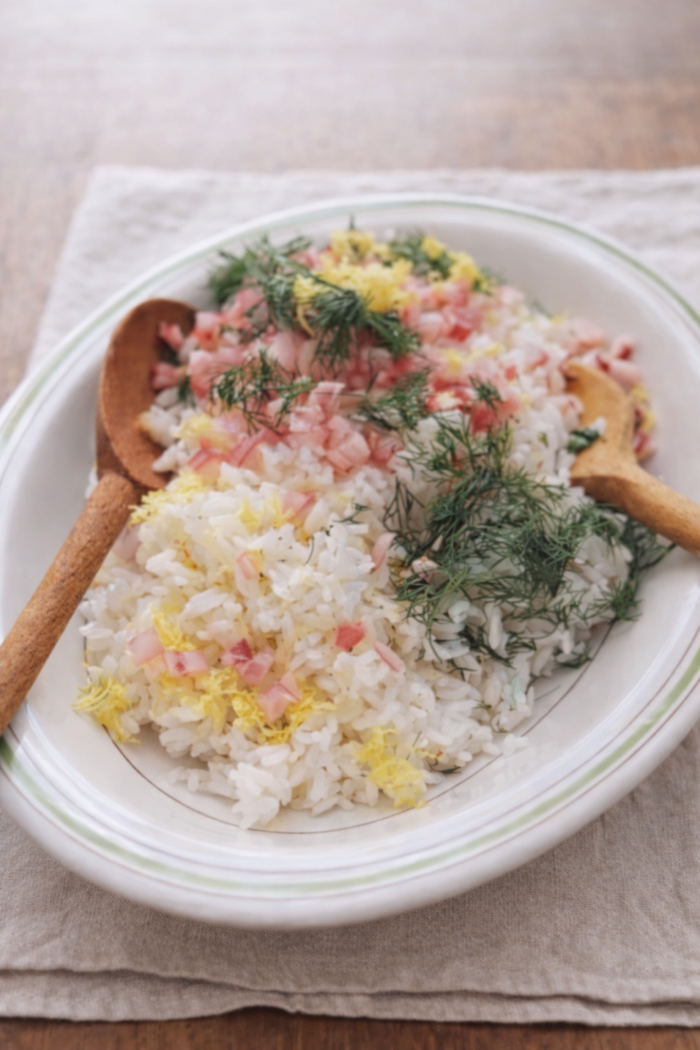 Easy herb rice salad with red onion, lemon zest, and fresh dill served in a white bowl on neutral linen