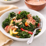 Easy massaged kale salad with creamy sun-dried tomato garlic dressing in a white bowl on a bright neutral table