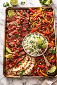 Sheet pan Southwestern steak with roasted peppers, chorizo, cilantro lime rice, and warm tortillas on a marble surface