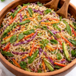 spring roll in a bowl salad tossed together in a wooden bowl with rice noodles coated in ginger dressing