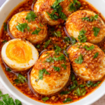 Viral egg boil recipe with hard-boiled eggs coated in spicy garlic seafood butter sauce and fresh parsley