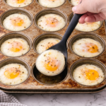 Oven-poached eggs cooked in a muffin tin with perfectly runny yolks—an easy, hands-off breakfast method.