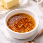small bowl of homemade brown butter with toasted milk solids on marble counter