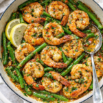 Calabrian chili garlic butter shrimp and green bean stir fry in a white enameled cast iron pot on a white marble countertop