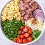 ingredients for chimichurri roast beef tortellini pasta salad in a bowl before mixing