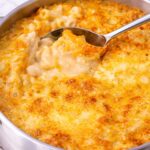 creamy baked mac and cheese with golden bubbly cheese crust in stainless steel pan