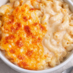 creamy classic mac and cheese with golden baked cheese crust in white bowl