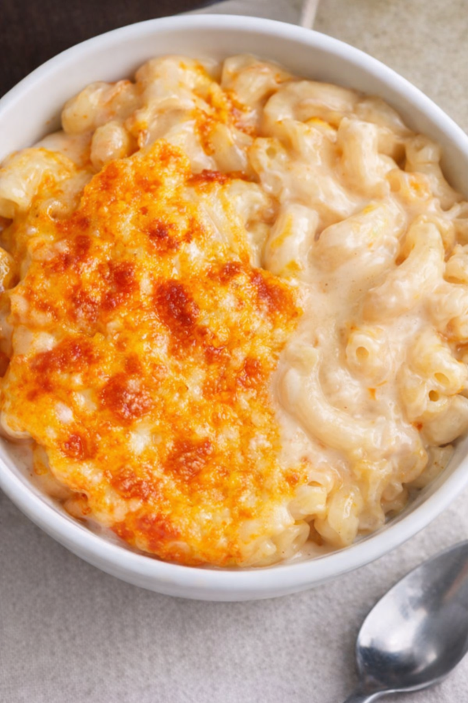 creamy classic mac and cheese with golden baked cheese crust in white bowl