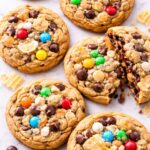 Crazy crack cookies made with brown butter chocolate chip dough loaded with M&Ms, white chocolate chips, butterscotch chips, and potato chips on a marble counter