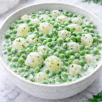 creamed peas and pearl onions in a creamy garlic herb sauce in a white bowl