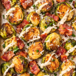 Crispy oven roasted Brussels sprouts with bacon and Caesar dressing on a sheet pan