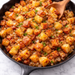 Golden, crispy home fries cooked in a cast iron skillet with caramelized onions