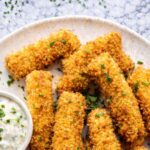 Golden crispy homemade fish sticks served with creamy tartar sauce and fresh lemon.