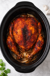 bird’s eye view of rotisserie style whole chicken cooked in crockpot on marble counter